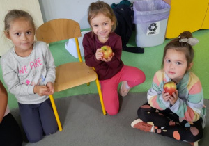 Dziewczynki pokazują jabłka, które otrzymały od pani Kasi
